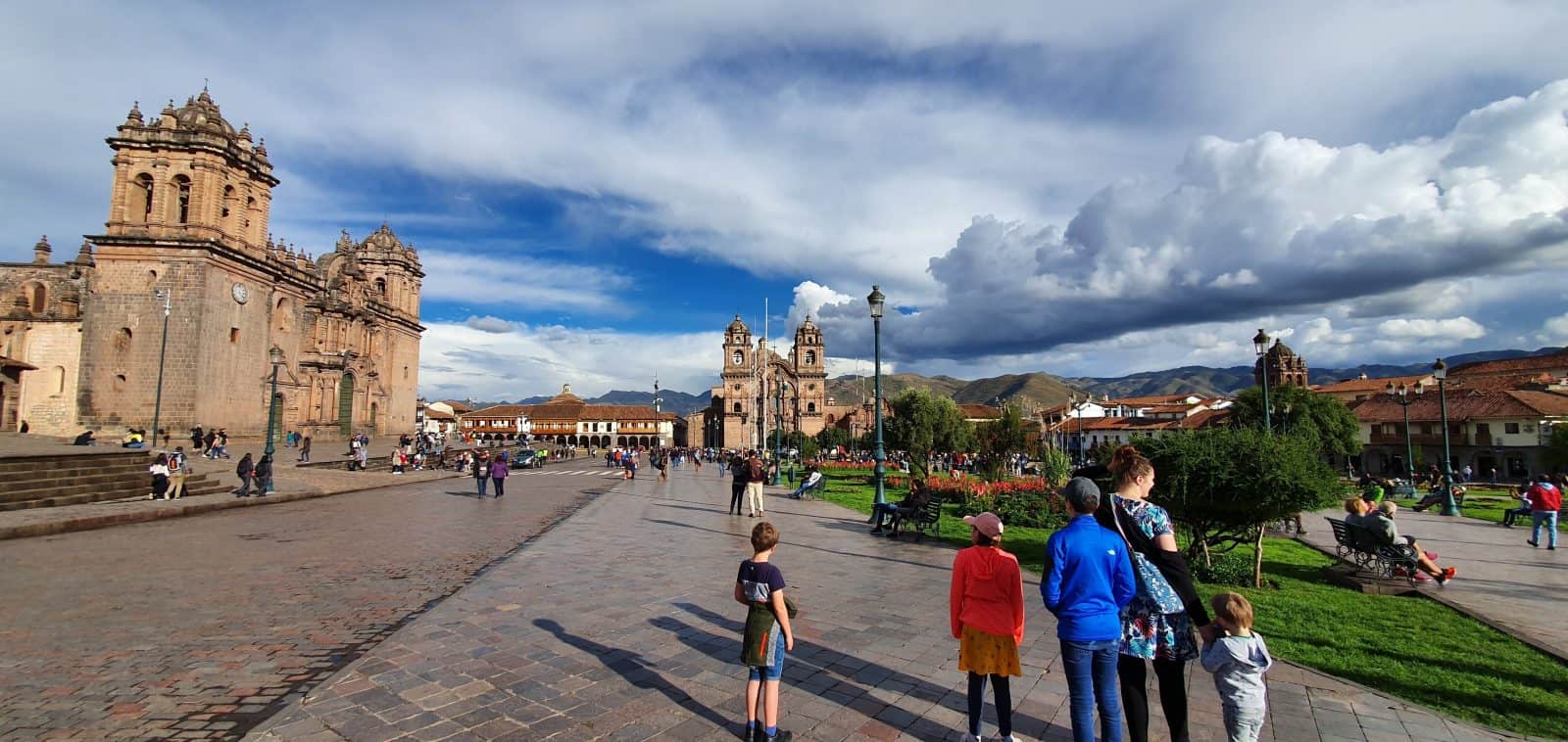 Photo of Cuzco's main square, the Plaza de Armas, showing the cathedral, another church and some surrounding mountains.